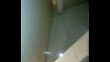 Cock urinating, wearing women's clothing and with painted nails.