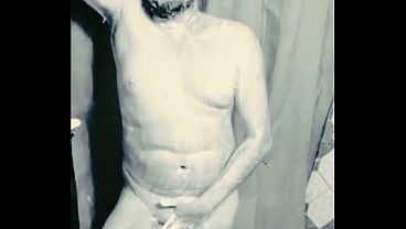 A fat middle-aged man was taking a shower, appearing as he was.