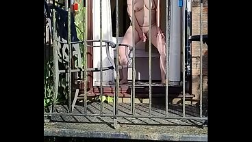 Naughty girl wanking in full view on the balcony