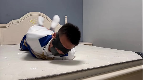 Kötözött ázsiai fiú kötél és bilincs között