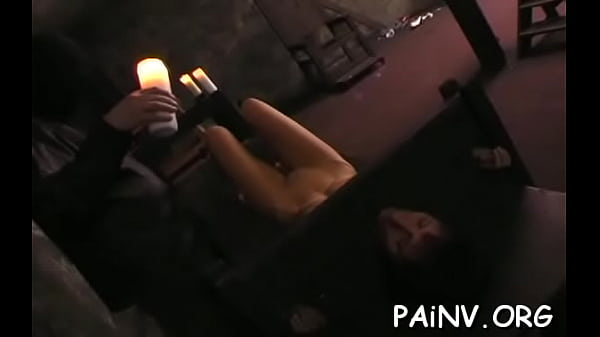 a naked woman crying as another woman is whipping her on the bed