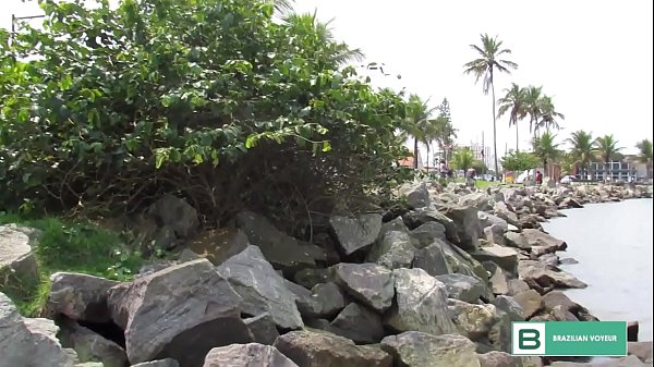 Blonde in Brazilian beach displays shaved pussy.  ( Full video in xvideos red )
